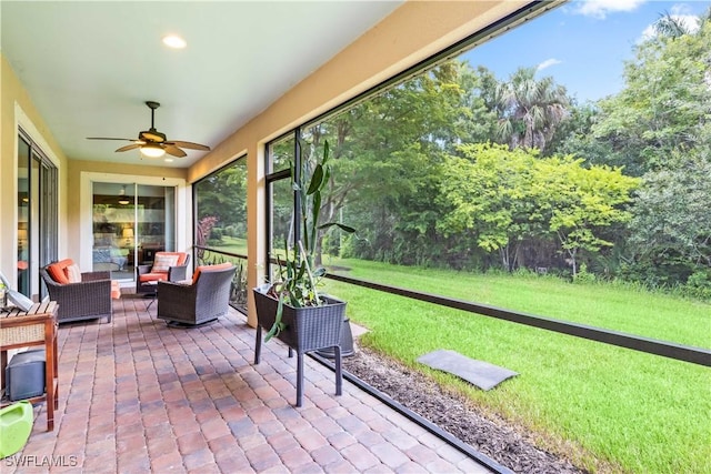 unfurnished sunroom with ceiling fan