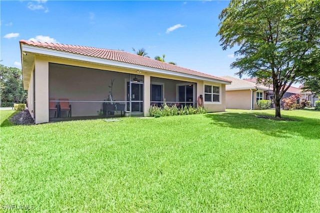 back of property featuring a lawn and a sunroom