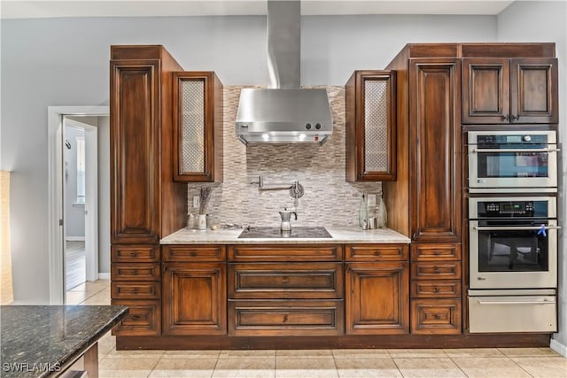 kitchen featuring stone counters, backsplash, exhaust hood, light tile patterned floors, and black electric cooktop