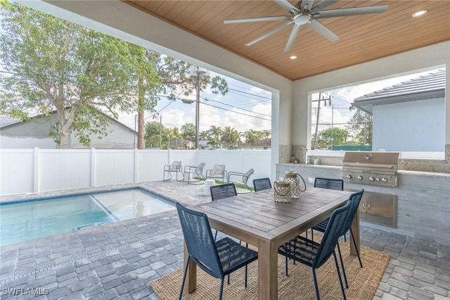 exterior space with grilling area, a patio, ceiling fan, and an outdoor kitchen