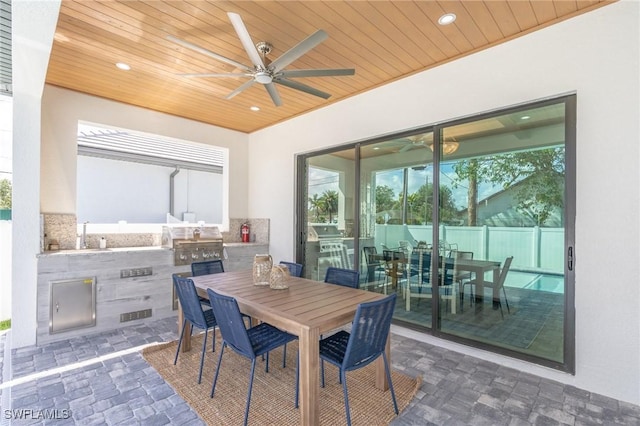 view of patio featuring exterior kitchen, area for grilling, sink, and ceiling fan