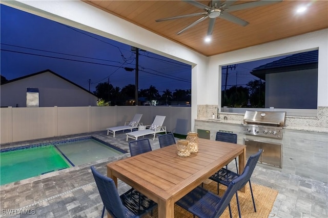 view of patio with a fenced in pool, an outdoor kitchen, and grilling area