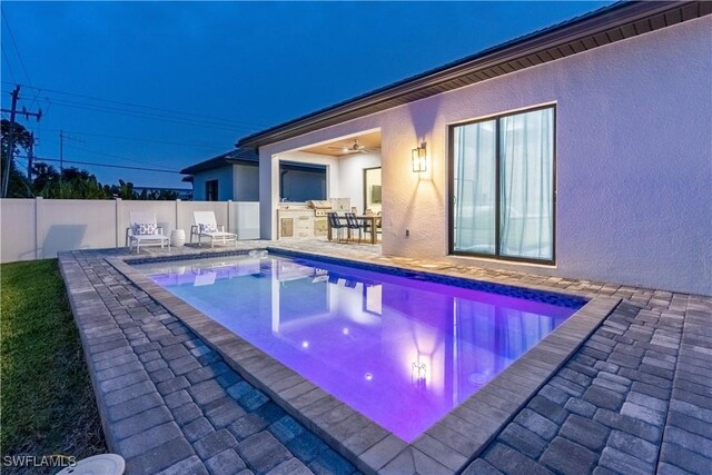 view of swimming pool featuring ceiling fan and a patio area