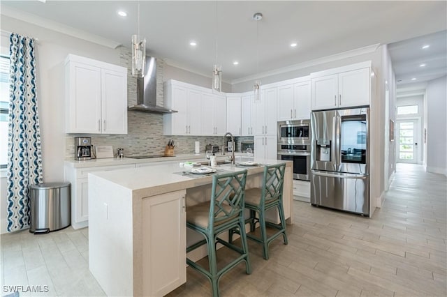 kitchen with stainless steel appliances, pendant lighting, a kitchen island with sink, and a breakfast bar area