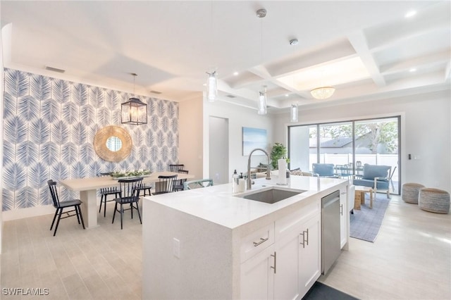 kitchen with sink, decorative light fixtures, stainless steel dishwasher, an island with sink, and white cabinets