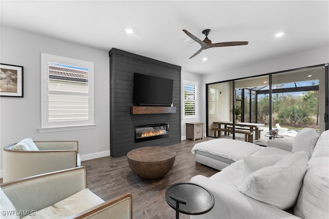 living room featuring a large fireplace and ceiling fan