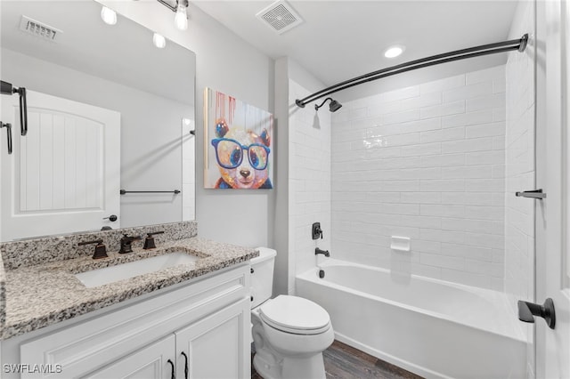 full bathroom with vanity, hardwood / wood-style flooring, toilet, and tiled shower / bath