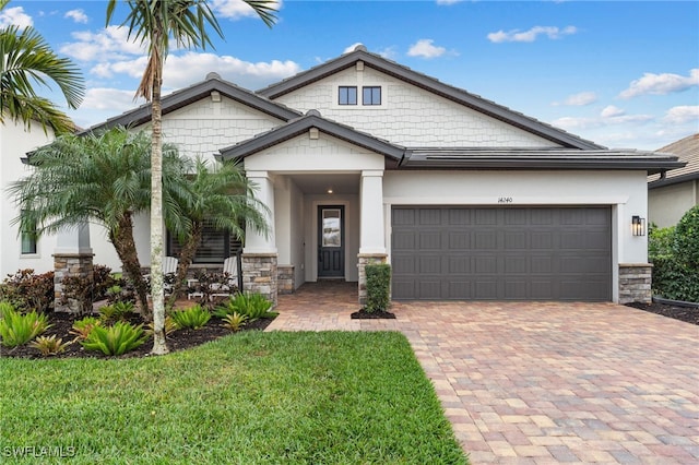 craftsman inspired home featuring a garage and a front lawn