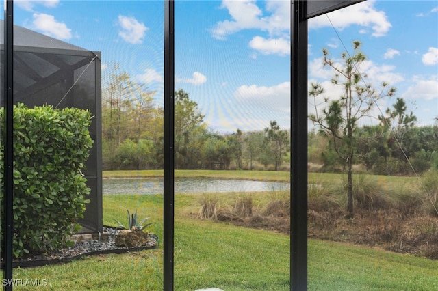 view of yard with a water view and a lanai