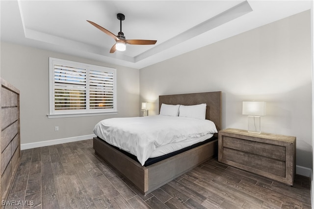 bedroom with a tray ceiling and ceiling fan