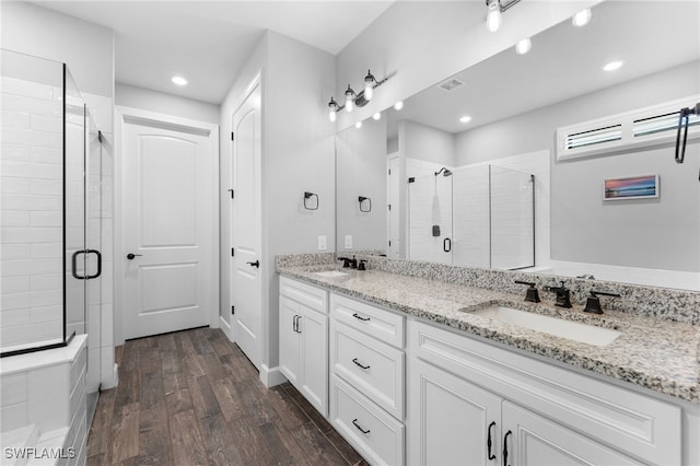 bathroom with hardwood / wood-style flooring, vanity, and walk in shower