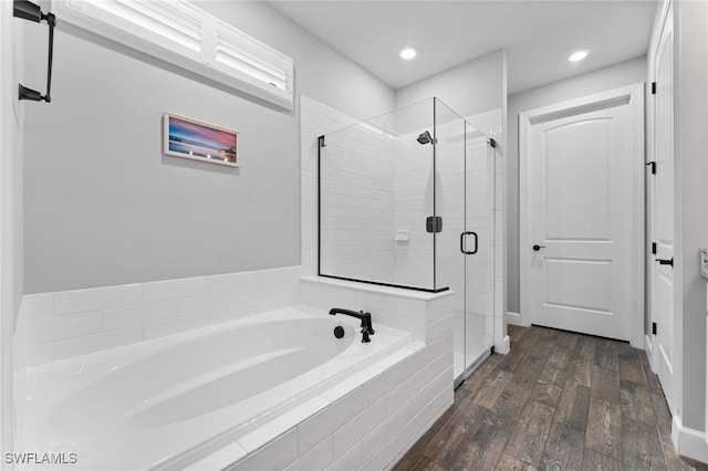 bathroom featuring hardwood / wood-style flooring and plus walk in shower