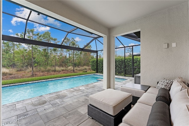 view of swimming pool with a patio area, outdoor lounge area, and glass enclosure