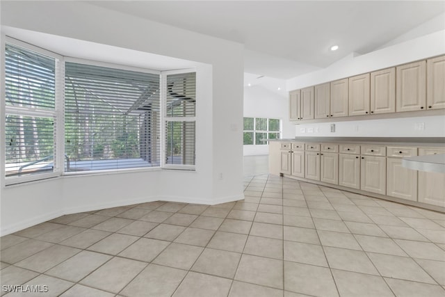 kitchen featuring lofted ceiling, a healthy amount of sunlight, and light tile patterned floors