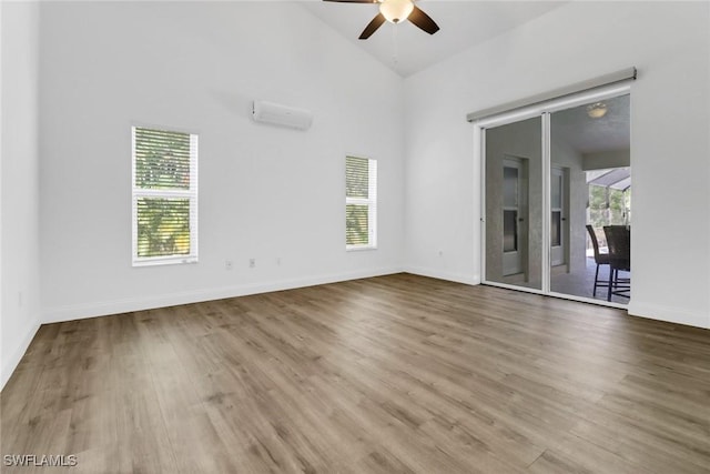 spare room featuring wood-type flooring, high vaulted ceiling, and a wealth of natural light