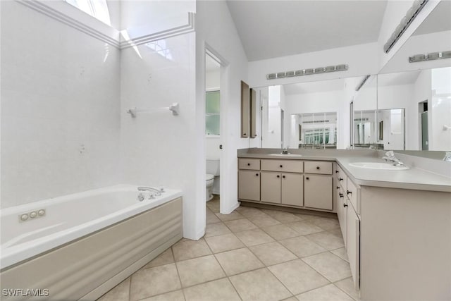 bathroom with a washtub, vanity, vaulted ceiling, tile patterned floors, and toilet