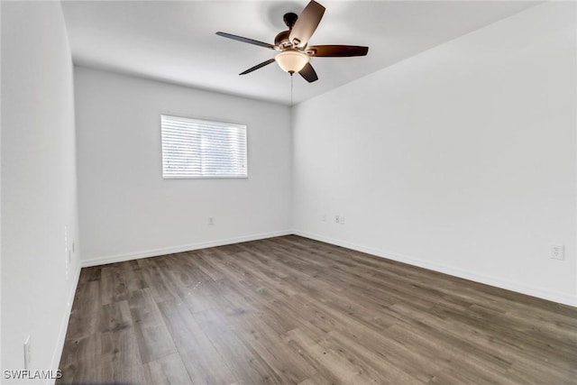 empty room with dark wood-type flooring and ceiling fan