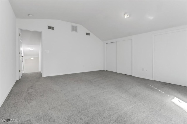 interior space with vaulted ceiling and carpet flooring