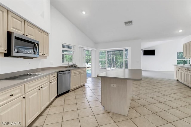 kitchen featuring light tile patterned flooring, sink, a center island, high vaulted ceiling, and stainless steel appliances