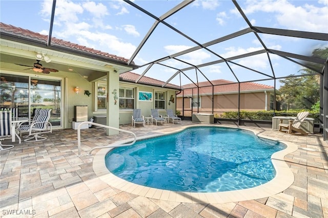 view of pool with ceiling fan, a lanai, and a patio area