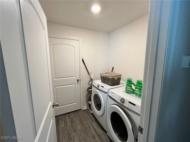 washroom with washing machine and clothes dryer and dark hardwood / wood-style flooring