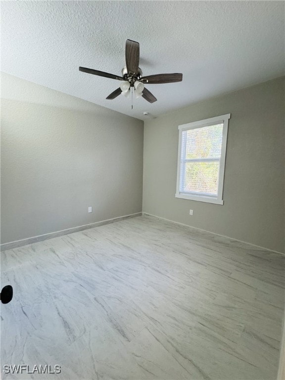 empty room with baseboards, a textured ceiling, and ceiling fan