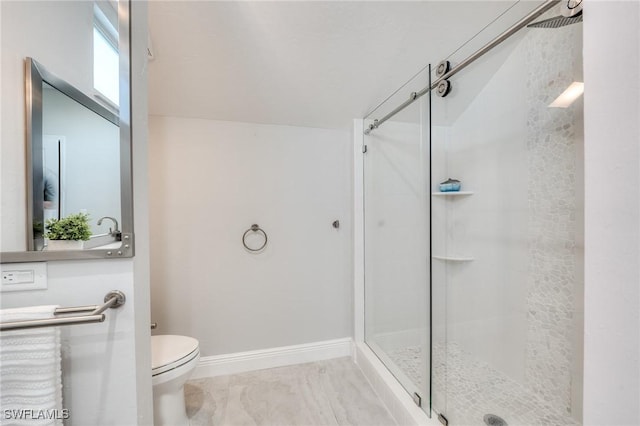 full bathroom with a stall shower, baseboards, and toilet