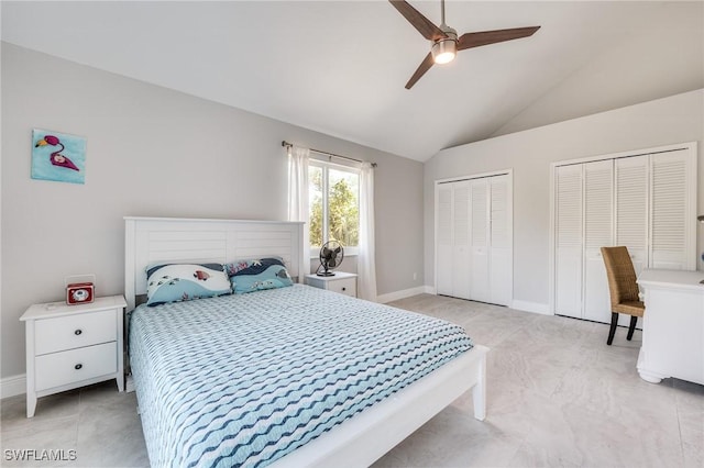 bedroom featuring lofted ceiling, ceiling fan, baseboards, and multiple closets