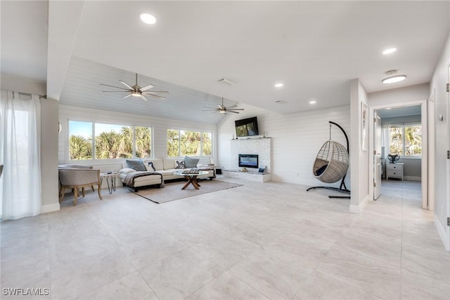 unfurnished living room with a ceiling fan, a glass covered fireplace, baseboards, and recessed lighting