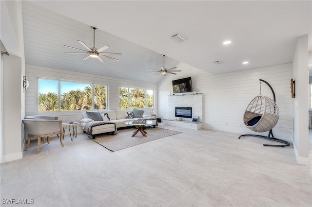 living room with recessed lighting, visible vents, a ceiling fan, a glass covered fireplace, and vaulted ceiling