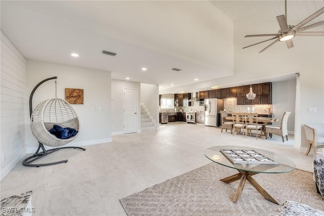 living room featuring stairway, baseboards, visible vents, and recessed lighting