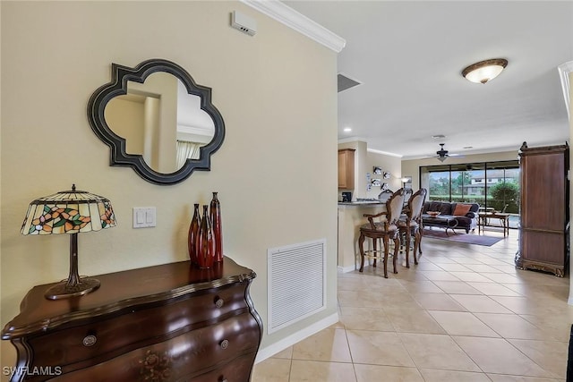 corridor with light tile patterned floors and crown molding