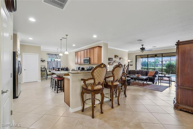 kitchen with light tile patterned flooring, a kitchen bar, ornamental molding, kitchen peninsula, and stainless steel appliances