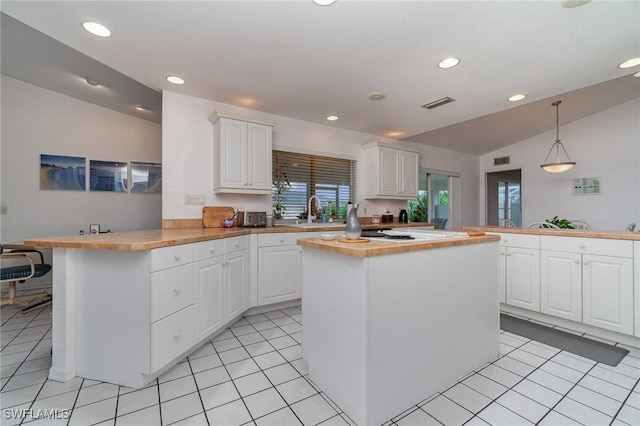 kitchen with white cabinetry, lofted ceiling, pendant lighting, and kitchen peninsula