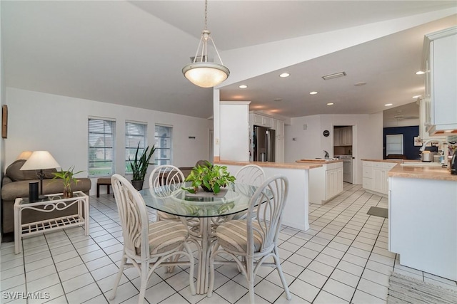 dining room with light tile patterned floors and vaulted ceiling