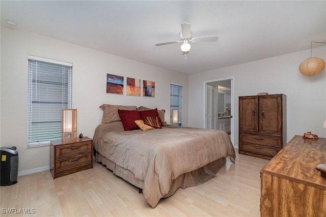 bedroom with ceiling fan, ensuite bath, and light hardwood / wood-style floors