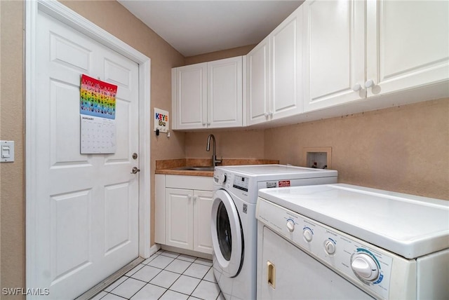 washroom with cabinets, sink, washer and dryer, and light tile patterned floors