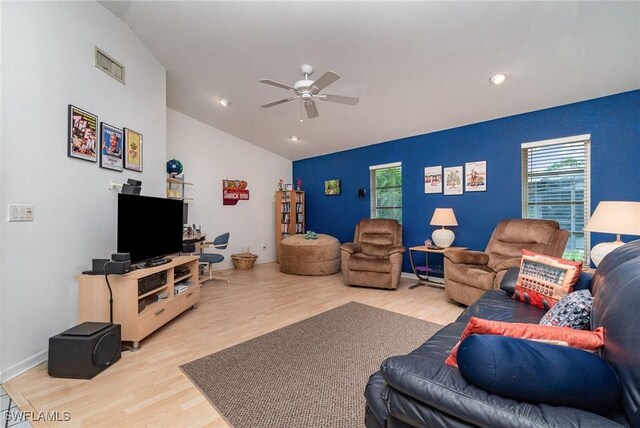 living room featuring ceiling fan, lofted ceiling, and light hardwood / wood-style flooring