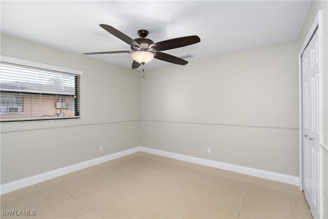 unfurnished room with light tile patterned floors, visible vents, baseboards, and ceiling fan