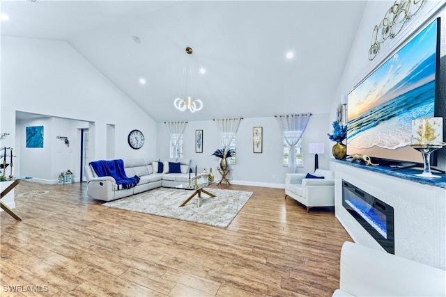 living room with light hardwood / wood-style flooring, high vaulted ceiling, and a chandelier