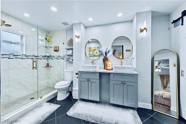 bathroom featuring tile patterned floors, toilet, a shower with door, and vanity