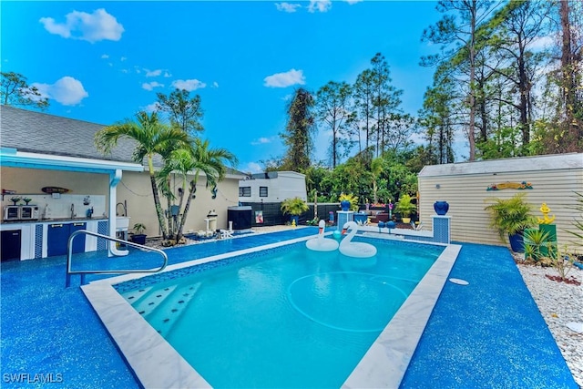 view of pool featuring area for grilling and sink