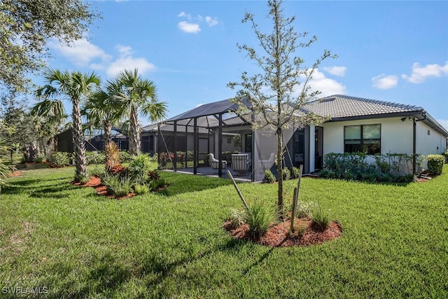 exterior space featuring a lawn, a patio, and glass enclosure