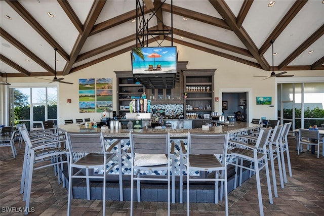 kitchen featuring beam ceiling, a kitchen breakfast bar, and stone countertops