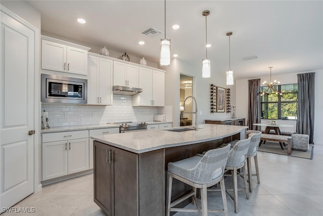 kitchen with a center island with sink, white cabinets, and appliances with stainless steel finishes