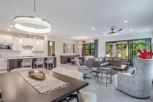 dining area featuring ceiling fan with notable chandelier