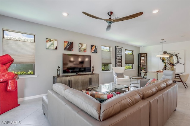 tiled living room with a wealth of natural light and ceiling fan