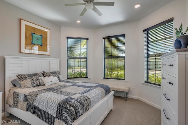 carpeted bedroom featuring multiple windows and ceiling fan