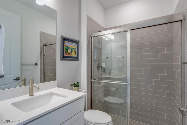 bathroom featuring vanity, toilet, and an enclosed shower