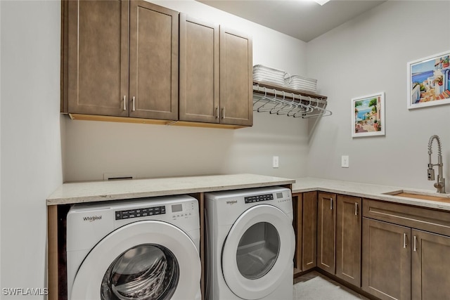 washroom with sink, washer and clothes dryer, and cabinets